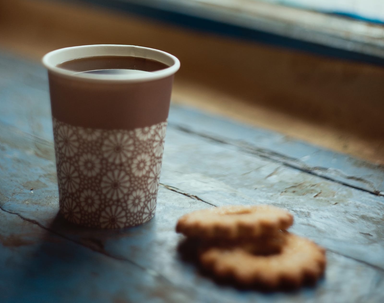 A cup of coffee with two butter cookies